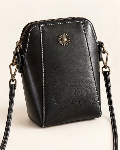 Cowhide Leather Micro Crossbody Phone Bag with Zip Closure — front three-quarter view on a warm white background