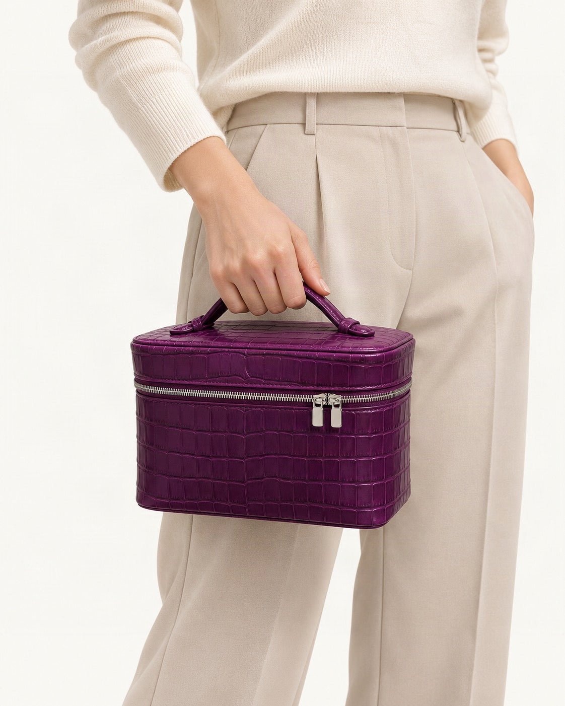 Cowhide Croc-Embossed Cosmetic Pouch held in hand by a model