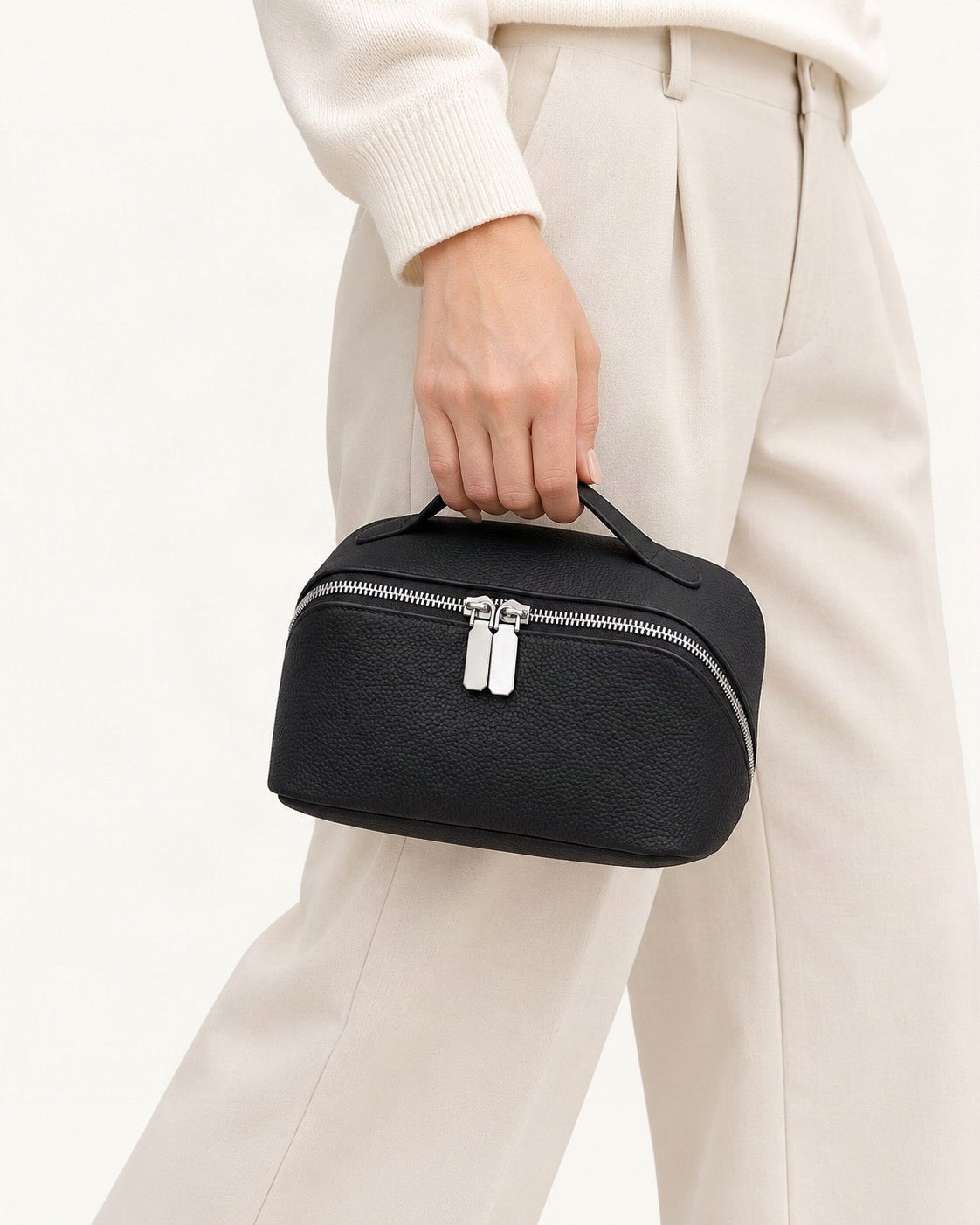 Top-Grain Cowhide Cosmetic Pouch held in hand by a model