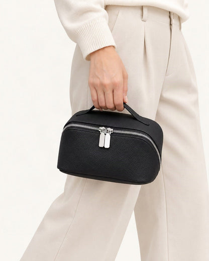 Top-Grain Cowhide Cosmetic Pouch held in hand by a model