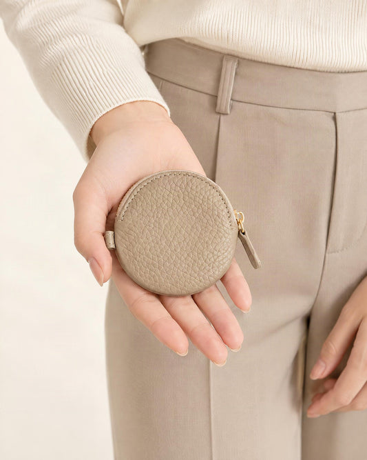 Cowhide Leather Mini Round Zip Pouch held in hand by a model