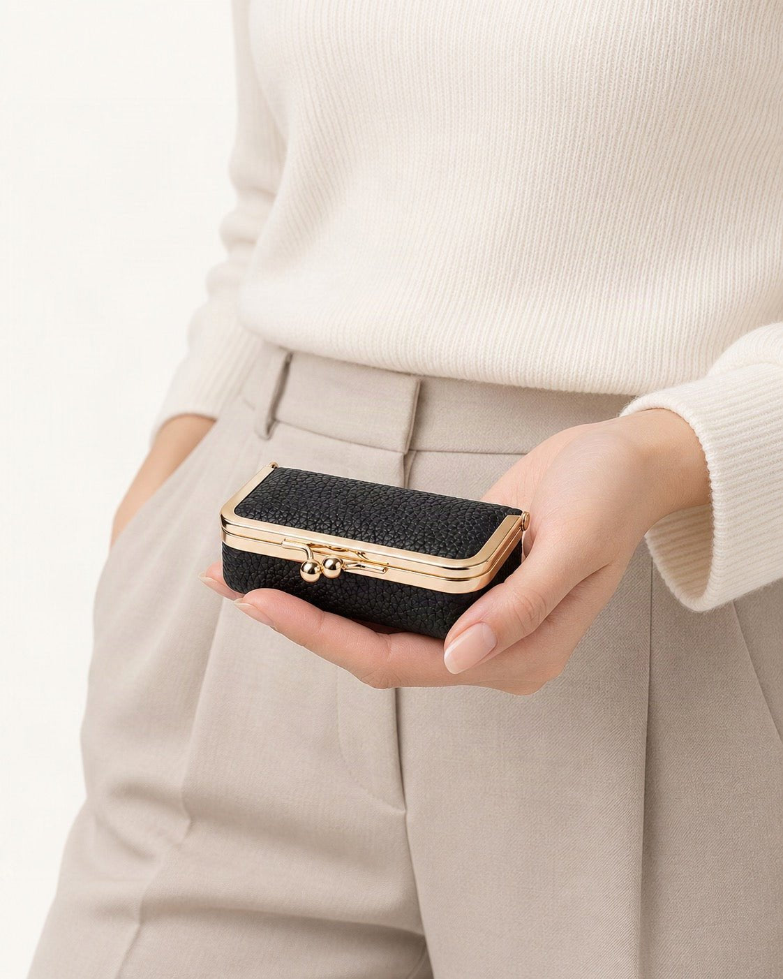 Top-Grain Cowhide Lipstick and Jewelry Pouch with Mirror held in hand by a model
