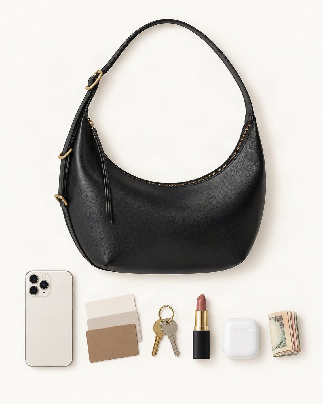 What fits in the Cowhide Crescent Shoulder Bag: smartphone up to 6.9 in, cards, keys, a lipstick, airpods in their case, a few banknotes folded over into a small stack, no complete flat bill face showing