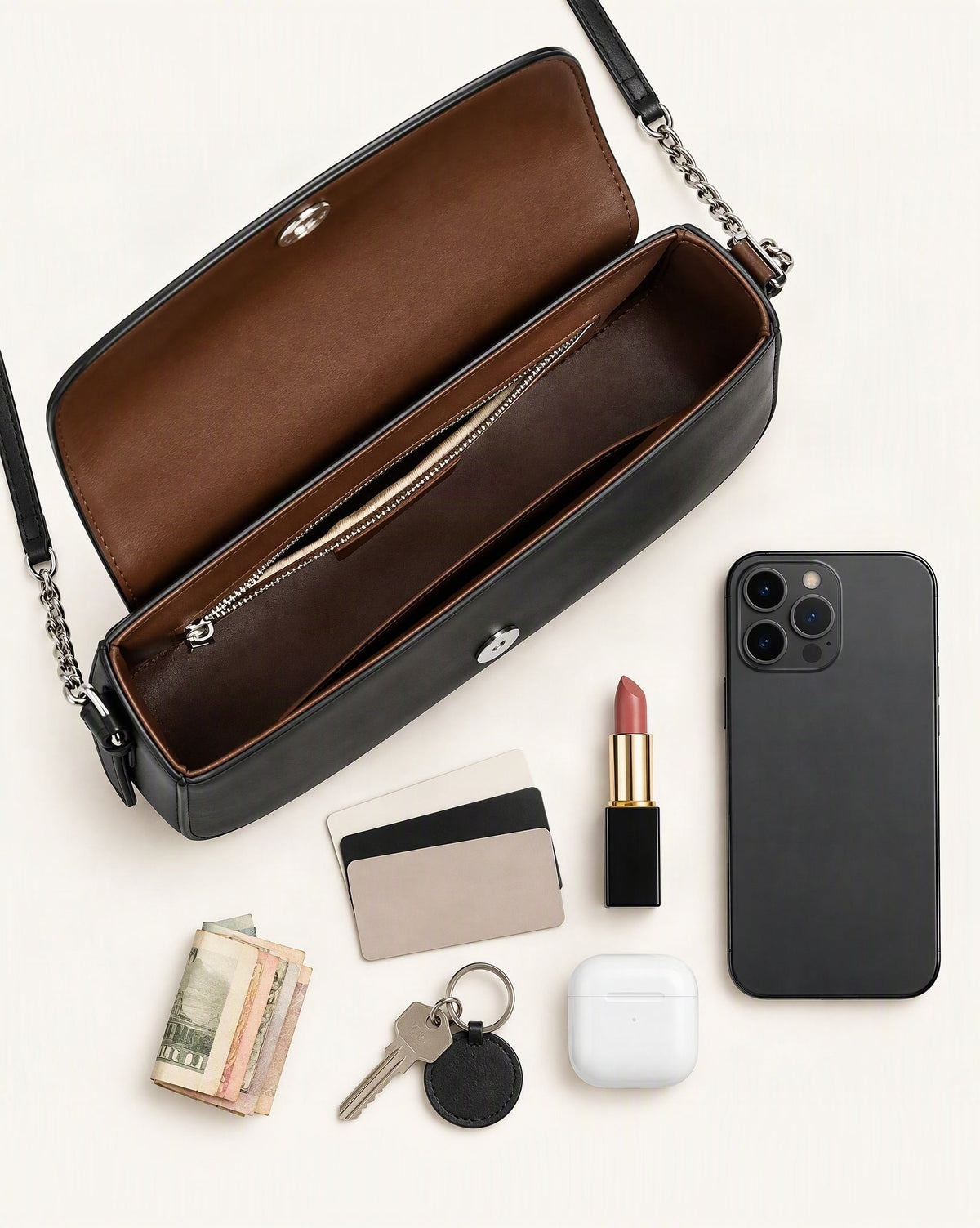 What fits in the Cowhide Leather Baguette Saddle Shoulder Bag: smartphone up to 6.9 in, cards, keys, a lipstick, airpods in their case, a few banknotes folded over into a small stack, no complete flat bill face showing