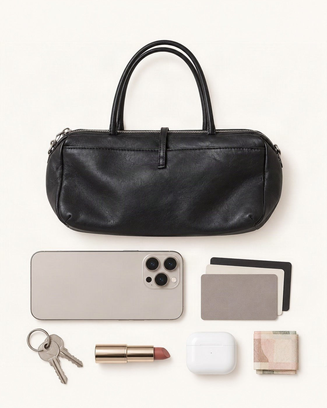What fits in the Lambskin Small Boston Bag: a 6.9-inch phone (iPhone 16 Pro Max), cards, keys, a lipstick, AirPods in their case, folded notes