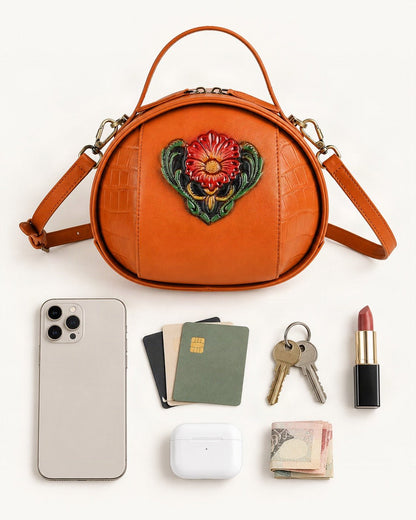 What fits in the Cowhide Embossed Round Crossbody Bag: smartphone up to 6.9 in, cards, keys, a lipstick, airpods in their case, a few banknotes folded over into a small stack, no complete flat bill face showing
