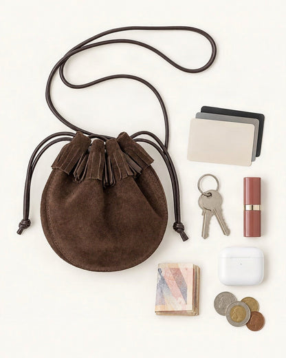 What fits in the Suede Cowhide Micro Bucket Bag: cards, keys, a lipstick, AirPods in their case, folded notes, coins