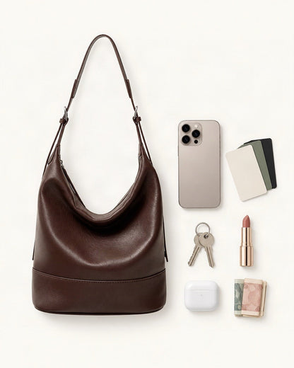 What fits in the Lambskin Small Shoulder Bucket Bag: a 6.9-inch phone (iPhone 16 Pro Max), cards, keys, a lipstick, AirPods in their case, folded notes