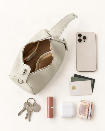 What fits in the Cowhide Mini Boston Bag Shoulder: smartphone up to 6.9 in, cards, keys, a lipstick, airpods in their case, a few banknotes folded over into a small stack, no complete flat bill face showing