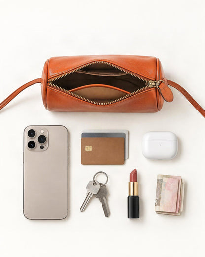 What fits in the Top-Grain Cowhide Mini Barrel Crossbody Bag: smartphone up to 6.9 in, cards, keys, a lipstick, airpods in their case, a few banknotes folded over into a small stack, no complete flat bill face showing