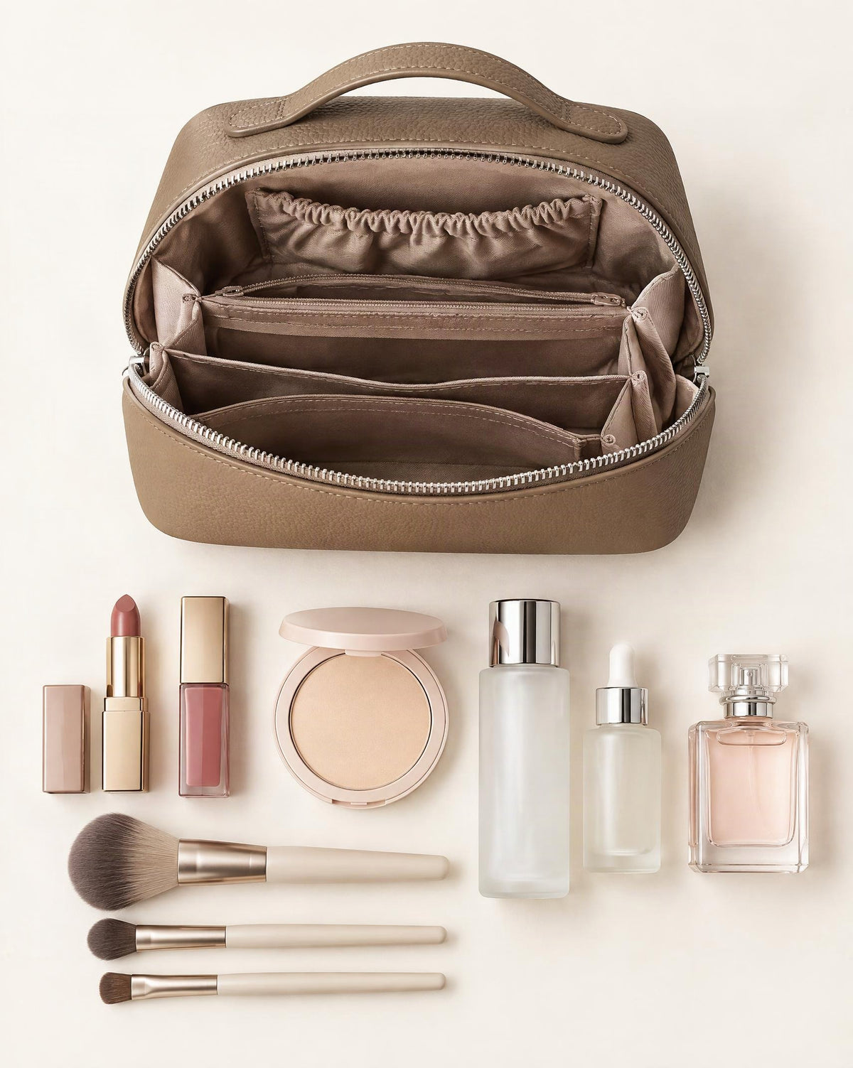 What fits in the Cowhide Leather Travel Pouch with Top Handle: lipsticks, a compact powder, skincare bottles up to 100 ml, makeup brushes, a small perfume