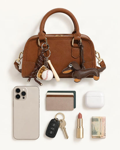 What fits in the Split Leather Small Bowling Bag: smartphone up to 6.9 in, cards, keys, a lipstick, airpods in their case, a few banknotes folded over into a small stack, no complete flat bill face showing
