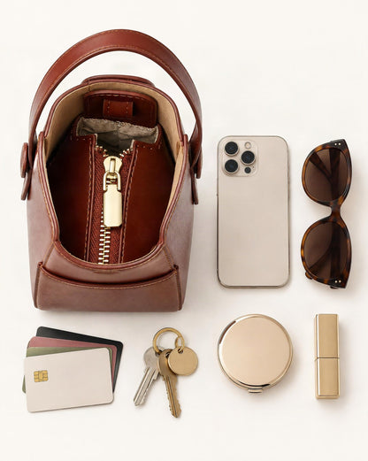 What fits in the Cowhide Leather Bucket Crossbody Bag: smartphone up to 6.9 in, sunglasses, a compact mirror, cards, keys, a lipstick