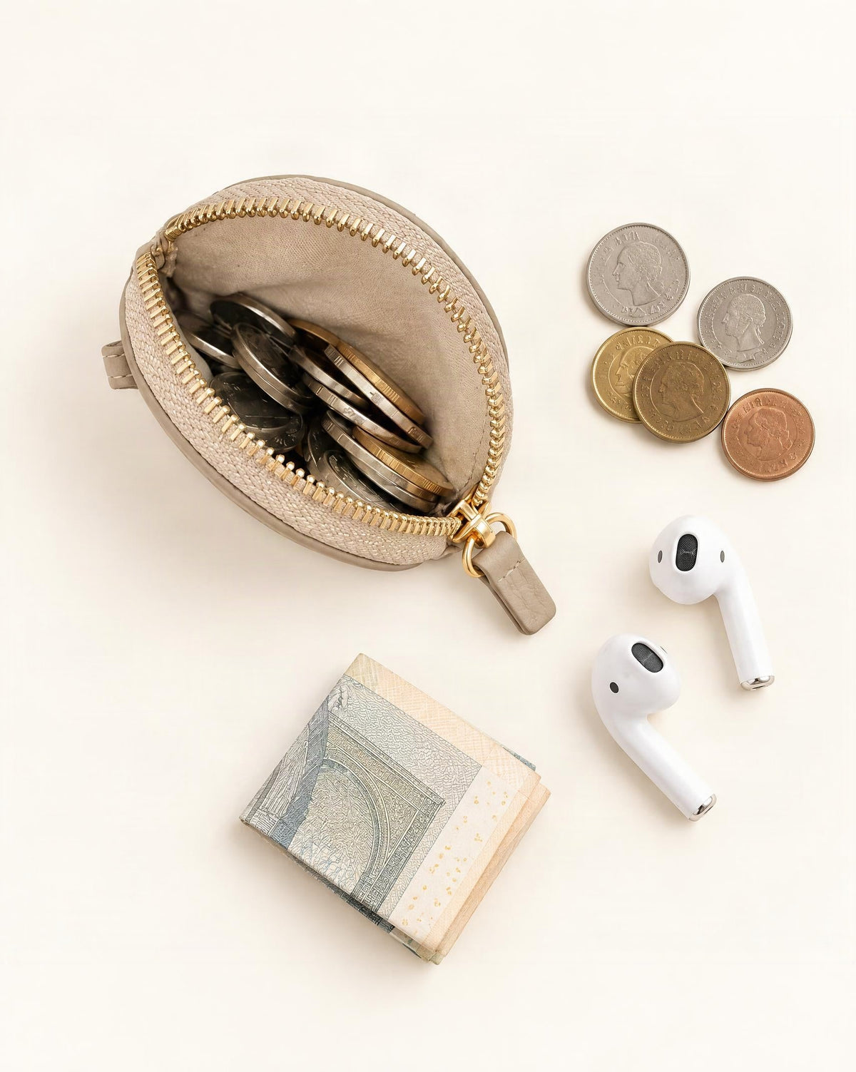 What fits in the Cowhide Leather Mini Round Zip Pouch: coins, earbuds without a case, a folded note
