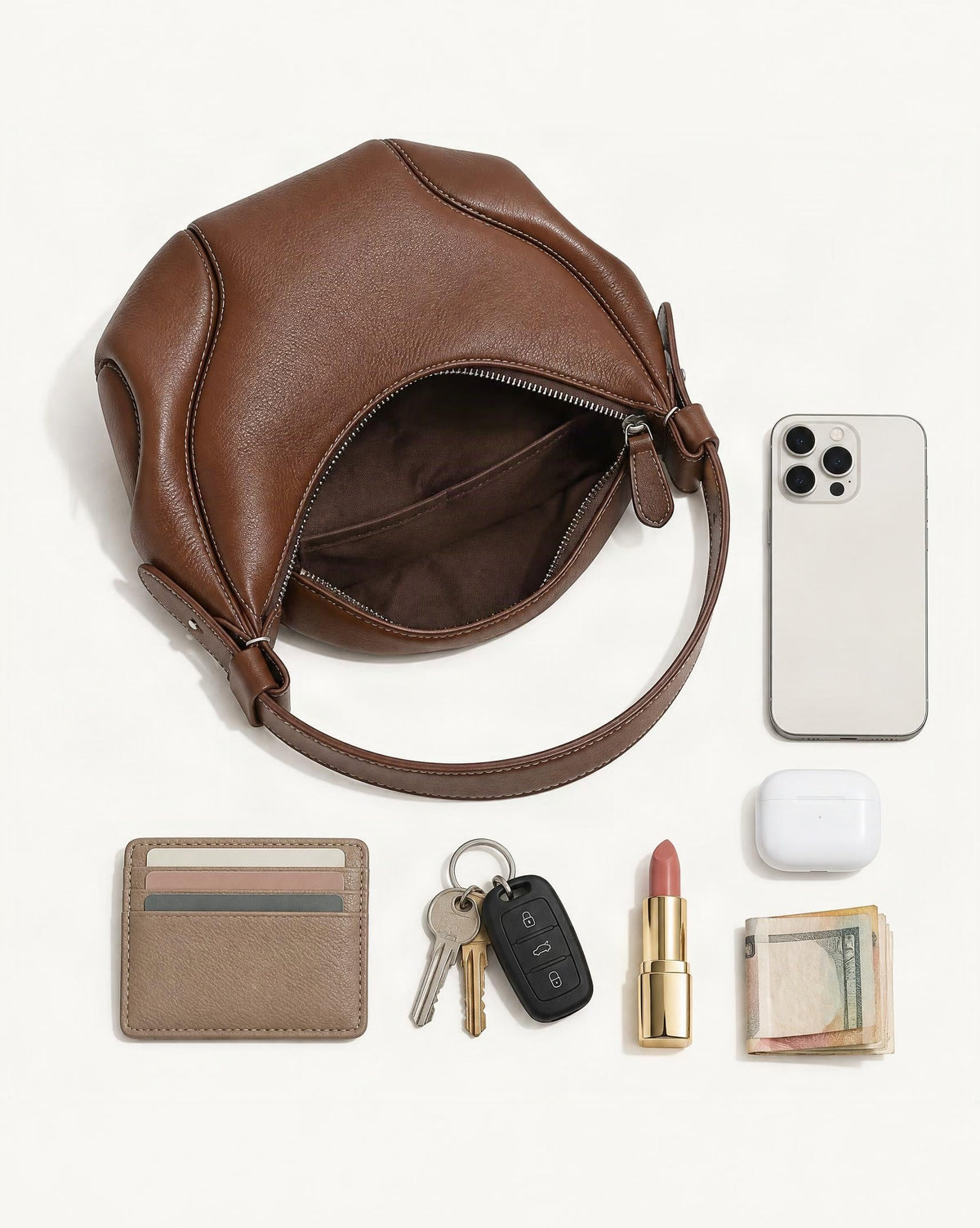 What fits in the Genuine Leather Underarm Shoulder Bag: smartphone up to 6.9 in, cards, keys, a lipstick, airpods in their case, a few banknotes folded over into a small stack, no complete flat bill face showing